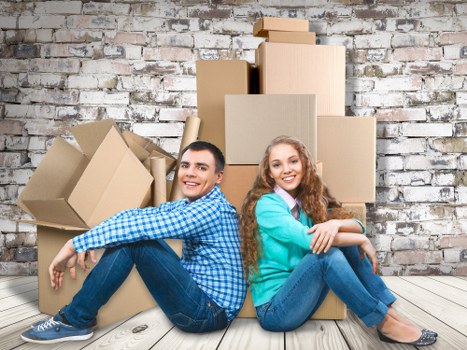 Professional movers carrying household items through a narrow staircase
